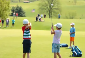 A group of young golfers practicing on a lush green golf course with spectators.